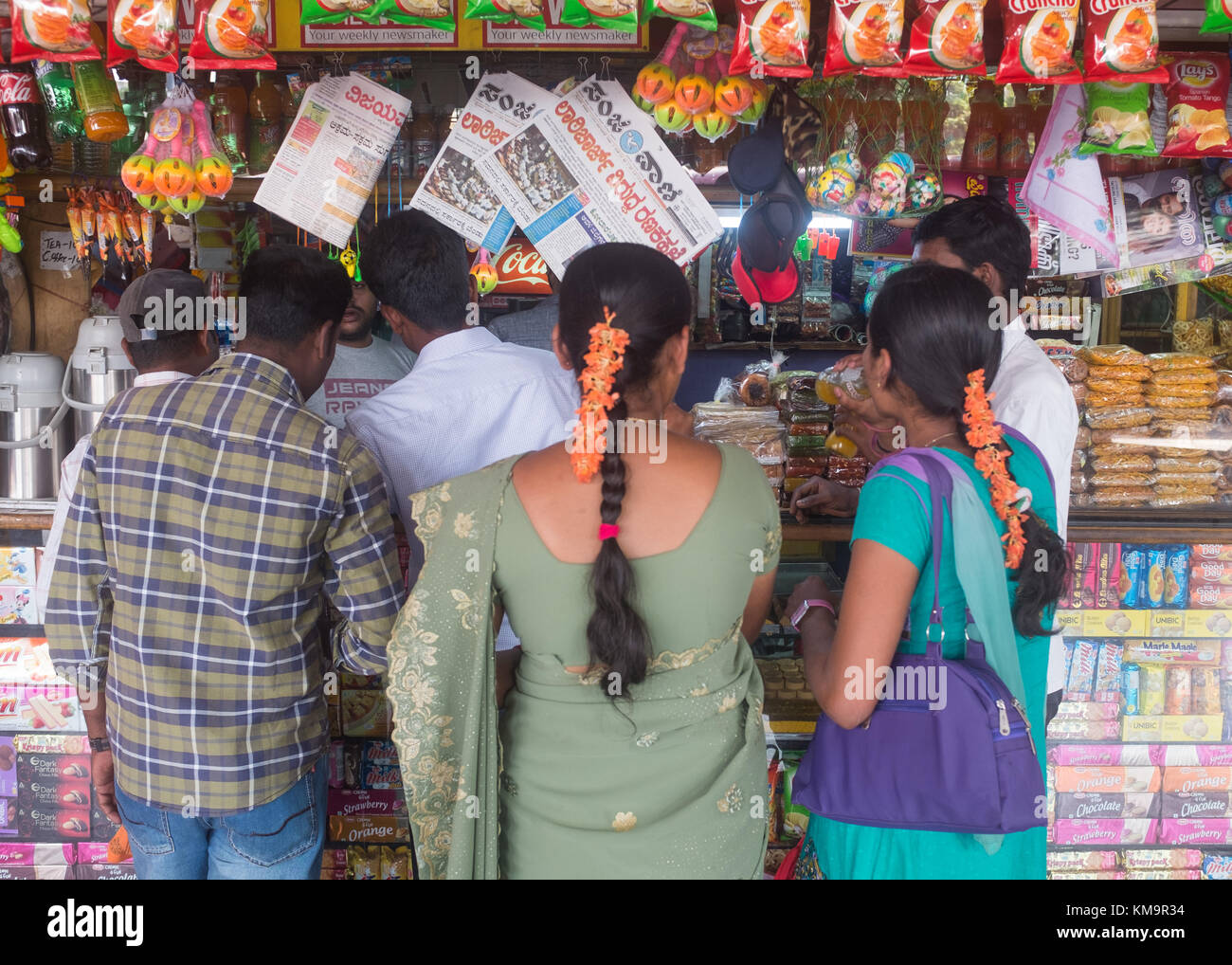 Personas que compran en el quiosco de la estación de autobuses, Mysore, Karnataka, India. Foto de stock