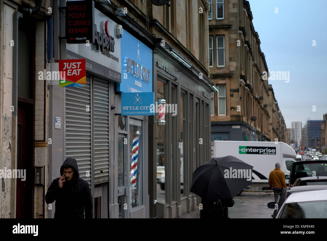 Niña con sombrilla día lluvioso húmedo en finnieston Argyle Street, Glasgow, Reino Unido Foto de stock
