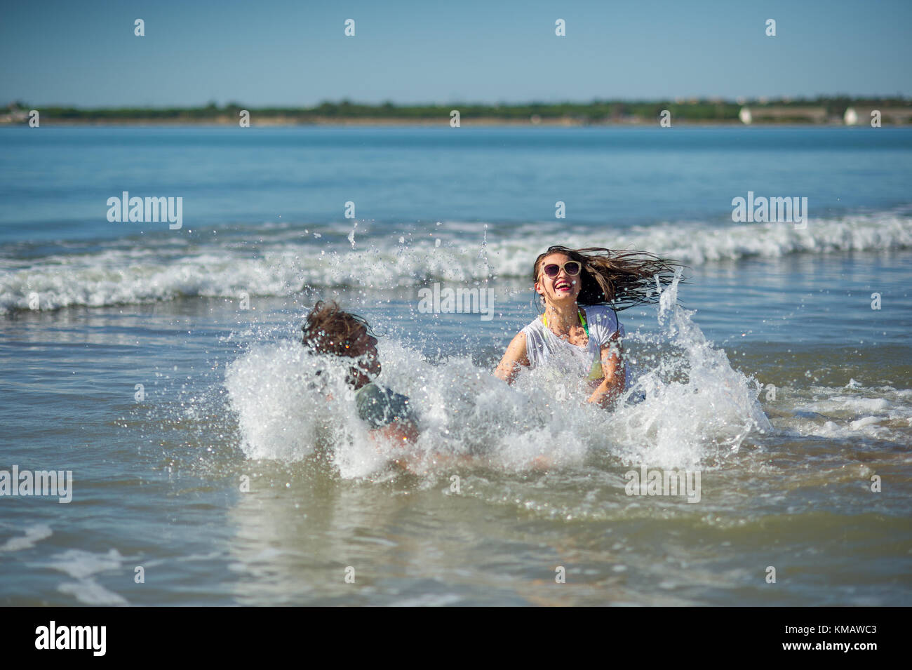 Pareja joven bañarse en el mar. chico y chica alegremente se hunde en el  agua Fotografía de stock - Alamy