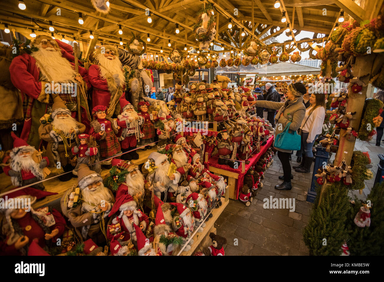 La gente de compras en puestos de mercado con productos navideños en Manchester los mercados de Navidad alrededor de la ciudad, Manchester, Inglaterra, Reino Unido. Foto de stock