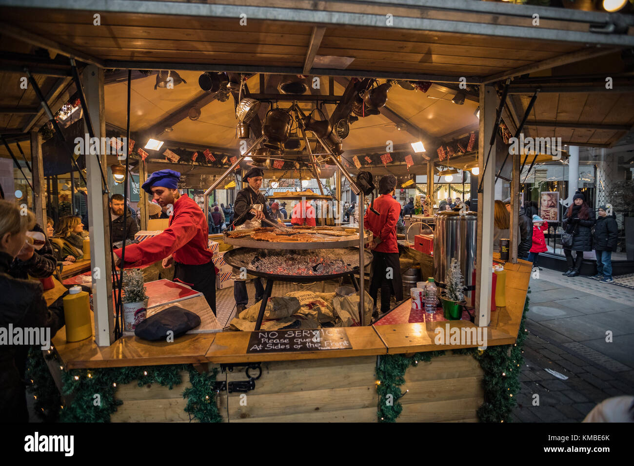 Trabajador de calado en el mercado que sirven comida en Manchester los mercados de Navidad alrededor de la ciudad, Manchester, Inglaterra, Reino Unido. Foto de stock
