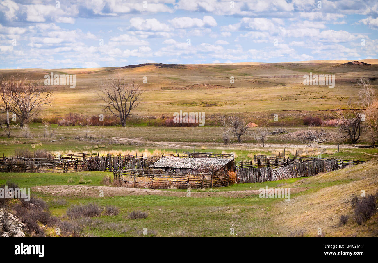 Granero abandonado y corrales de ganado en las colinas de la pradera de Wyoming Foto de stock