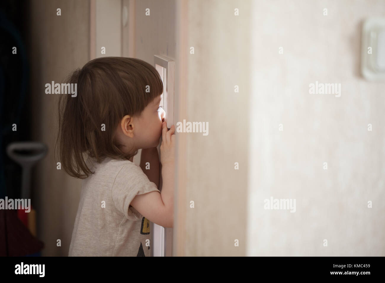El chico se ve en la ventana de la puerta. Un niño espiar a sus padres  desde detrás de la puerta del dormitorio cerrada Fotografía de stock - Alamy