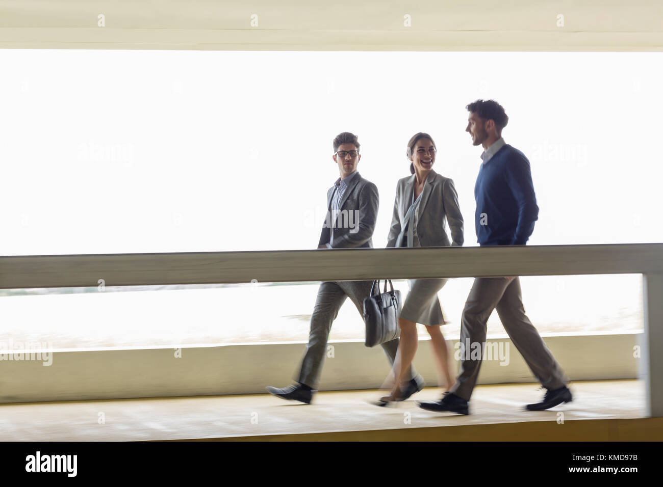 Gente de negocios caminando y hablando a lo largo de la pasarela Foto de stock