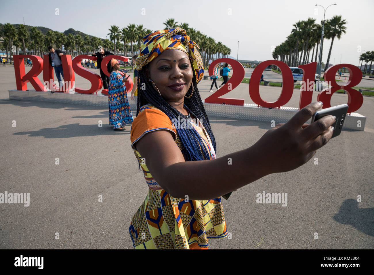 Una chica de Camerún hace un selfie sobre los antecedentes de la inscripción "Rusia 2018" en el parque olímpico de Sochi, Krasnodar, Rusia Foto de stock