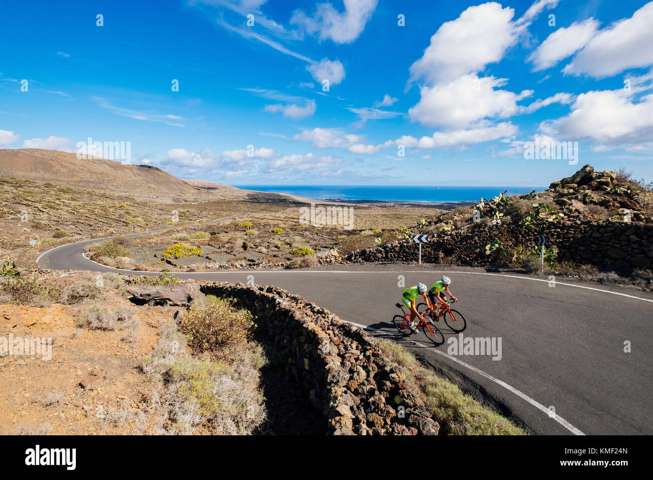 Dos ciclistas de carretera cabalgando al lado de la otra en la carretera, Lanzarote, Islas Canarias, España Foto de stock