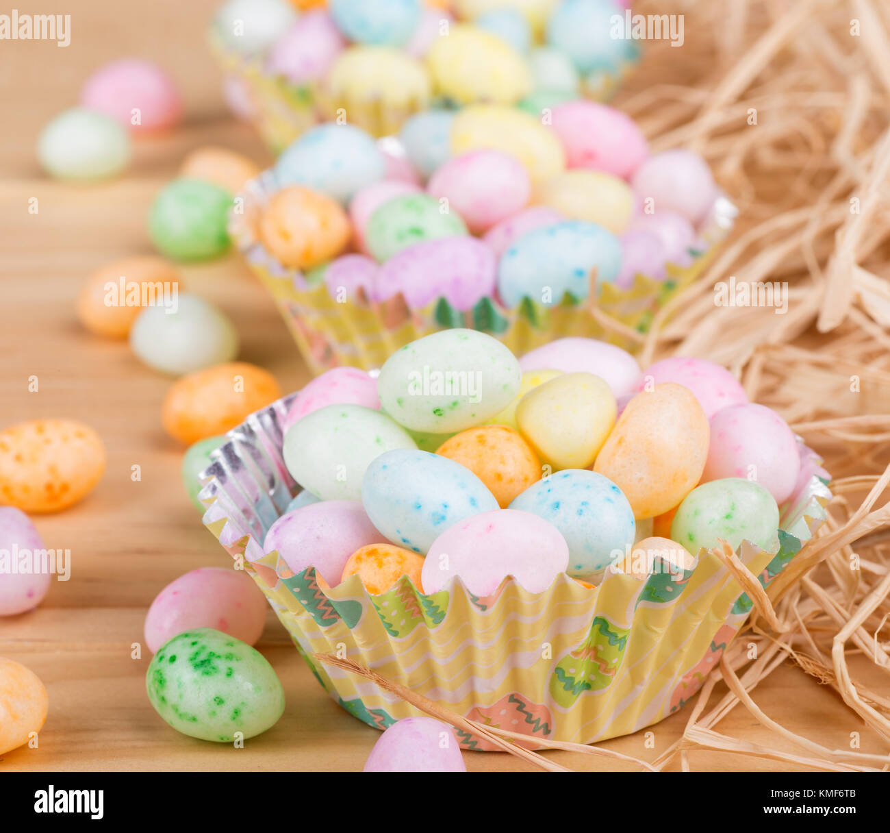Pascua coloridos Jelly Beans en tazas de papel sobre una superficie de madera Foto de stock