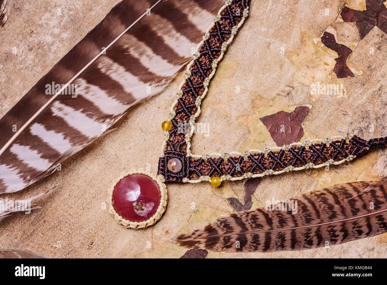 Macrame meterial gemstone natural Handmade necklace con antecedentes de pluma silvestre Foto de stock