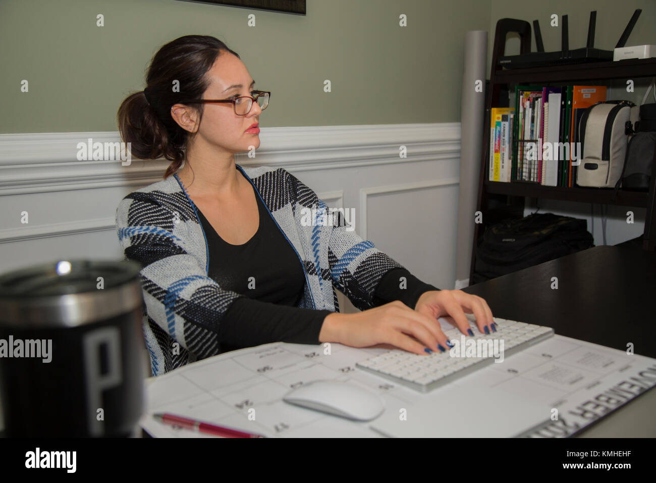 Hermosa hembra blanca 20-25 años estudiando en su oficina en casa. Foto de stock