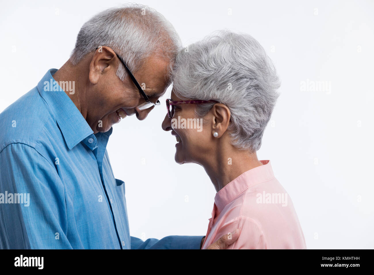 Las parejas ancianas mirarse tocar jefes Foto de stock