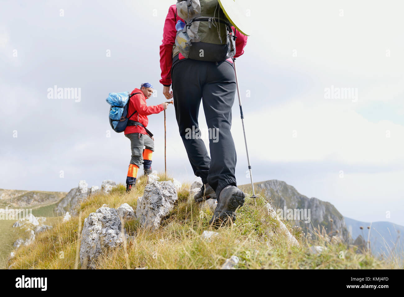 Cerca de las piernas de los jóvenes excursionistas caminando en la ruta del país. Pareja joven trail despertarse. Centrarse en el calzado de senderismo Foto de stock