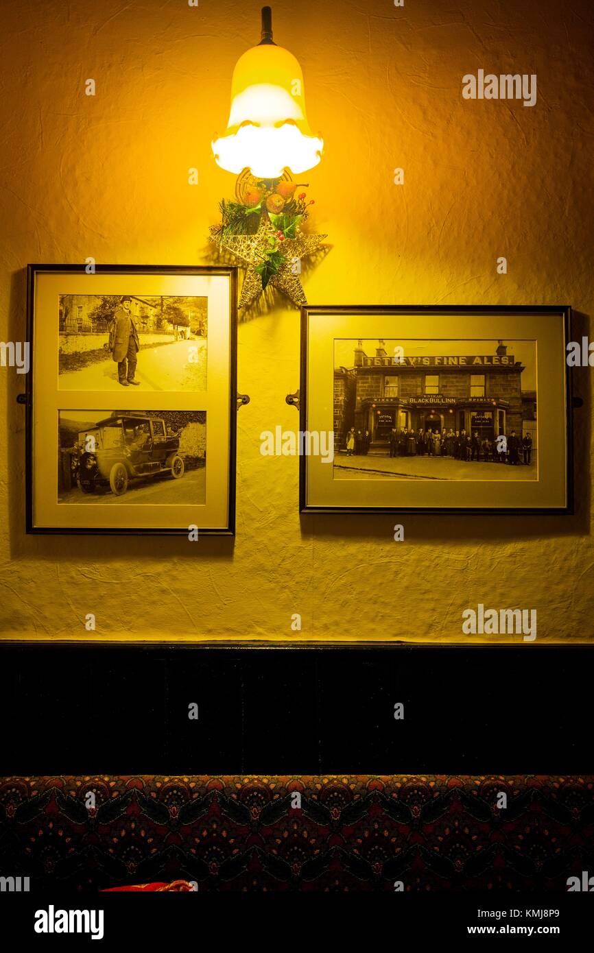 Pared de un pub con dos vintage fotos y una lámpara encendida. Starbotton, Skipton, Yorkshire Dales, North Yorkshire, Inglaterra, Reino Unido. Foto de stock