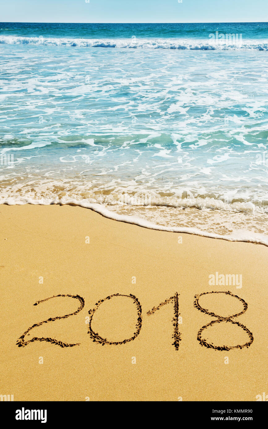Dígitos de 2018 sobre la arena de la playa costa - Concepto de navidad y año nuevo Foto de stock