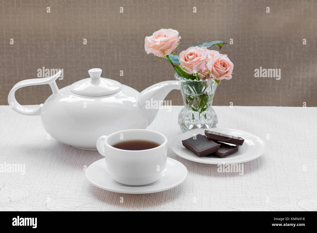 La tetera, taza, rosas y chocolate en una placa Foto de stock