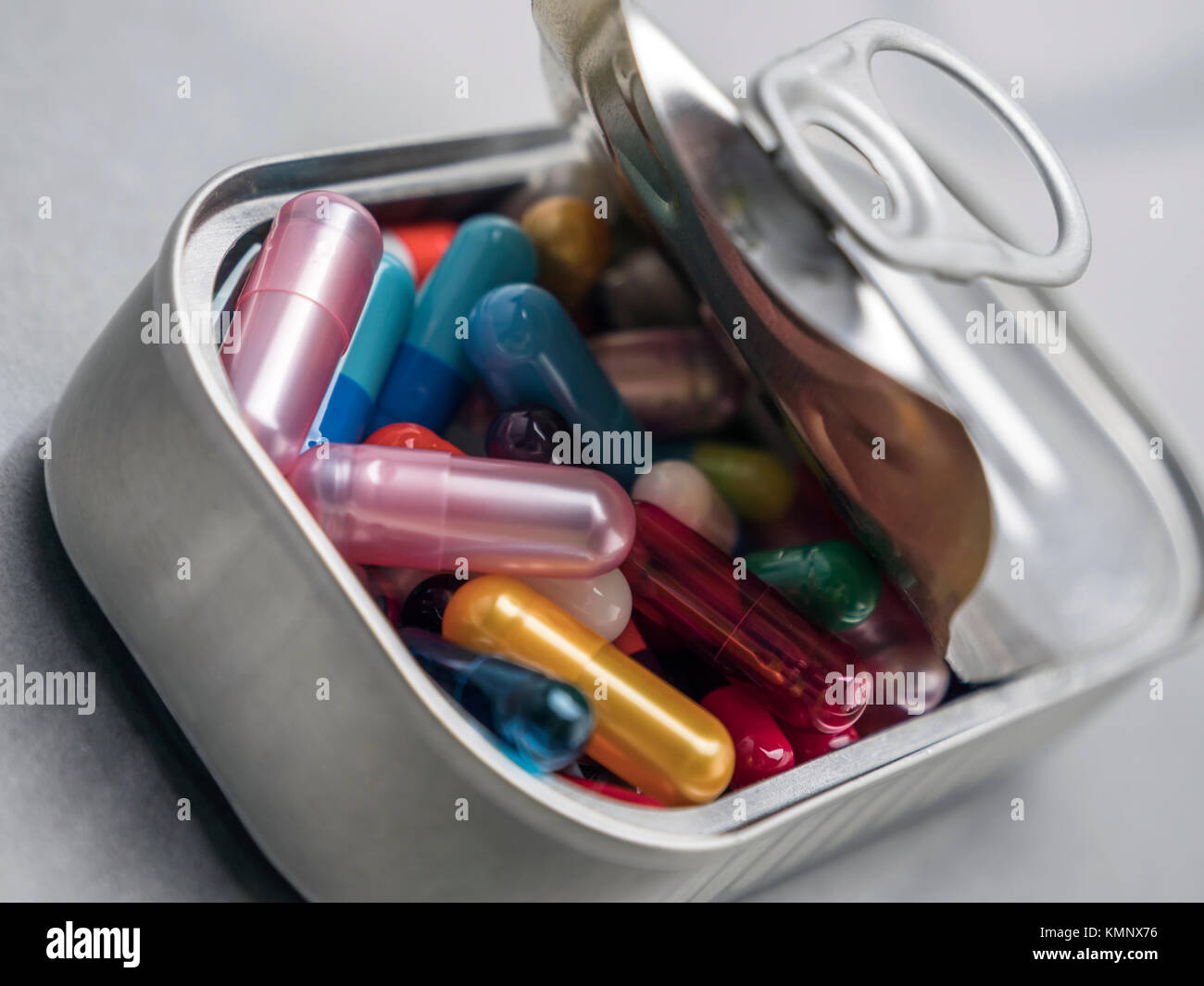 Estaño metálico contiene pastillas de color blanco y rojo, imagen conceptual Foto de stock