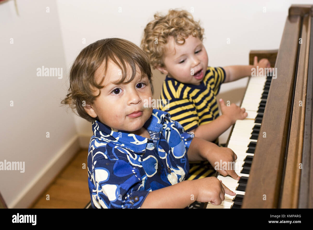 Dos chicos de 2 años tocando el piano. Uno tiene un helado en su rostro  Fotografía de stock - Alamy