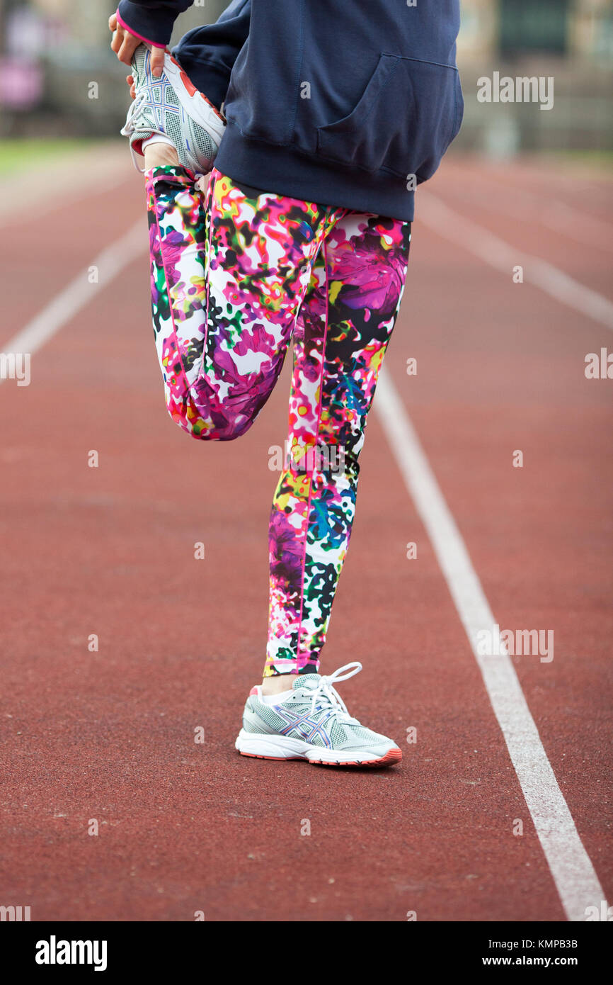 Piernas deportes chica en medias y brillante gris zapatillas sobre la senda  de footing. Mujer de calentamiento antes de correr Fotografía de stock -  Alamy