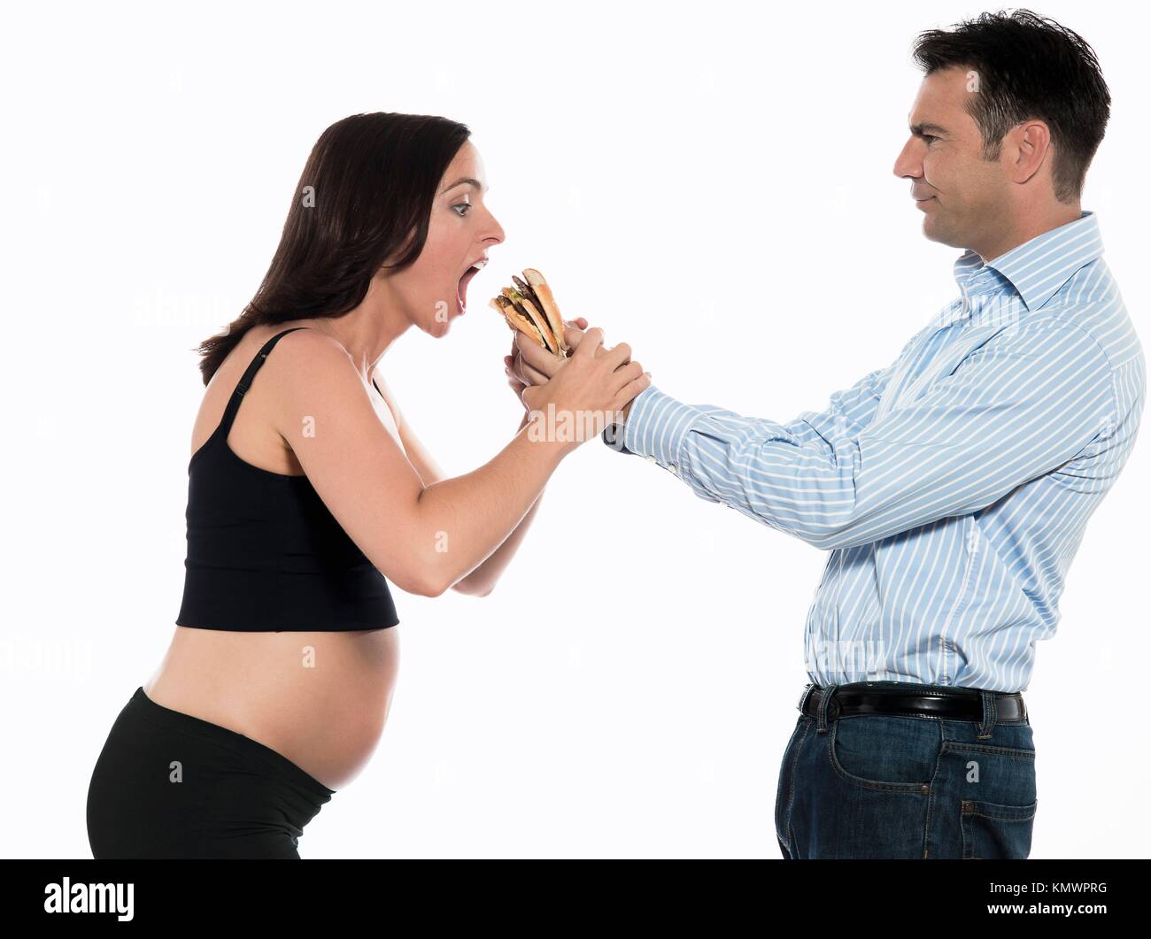 Par esperando bebé hambriento mujer comer hamburguesas estudio aislado sobre fondo blanco. Foto de stock