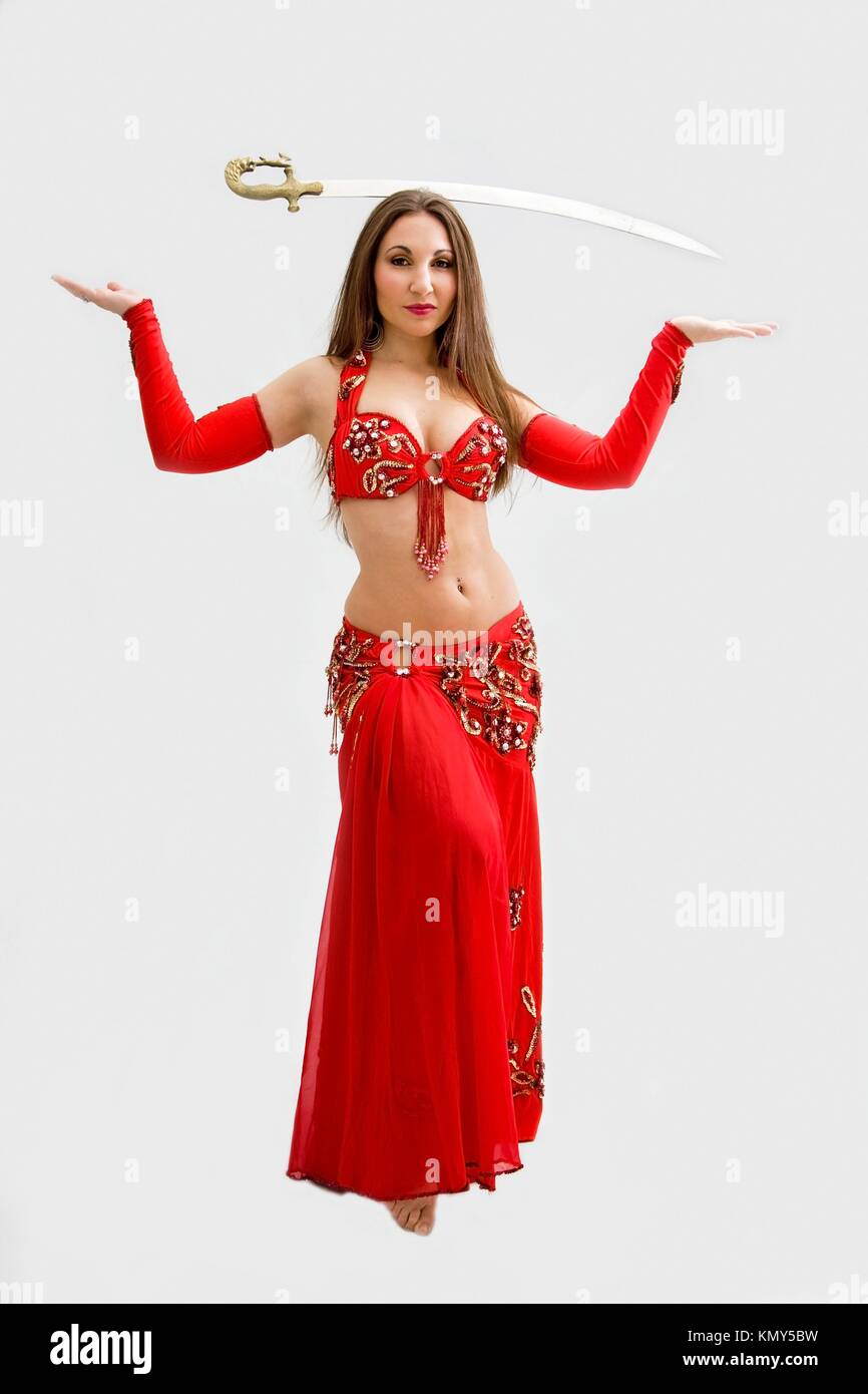 Bella bailarina de danza del vientre en traje rojo con la espada