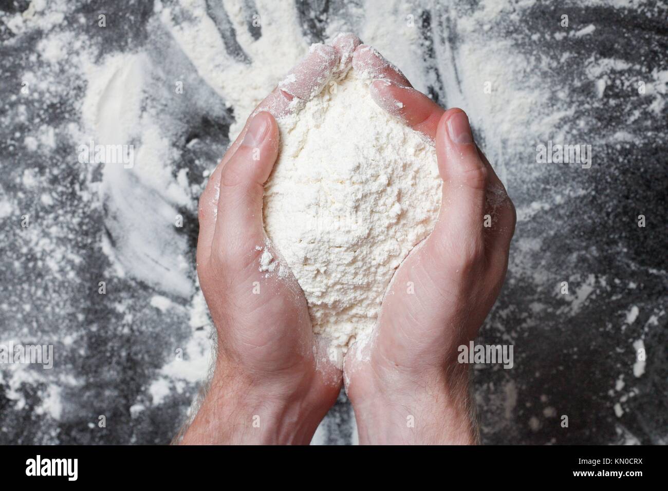 Manos sosteniendo la harina de trigo blanco Foto de stock