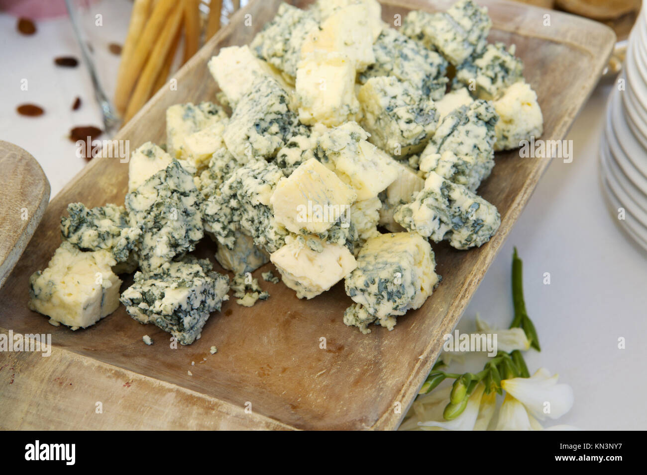 Cubos de delicioso queso azul en una bandeja de madera, España. Foto de stock
