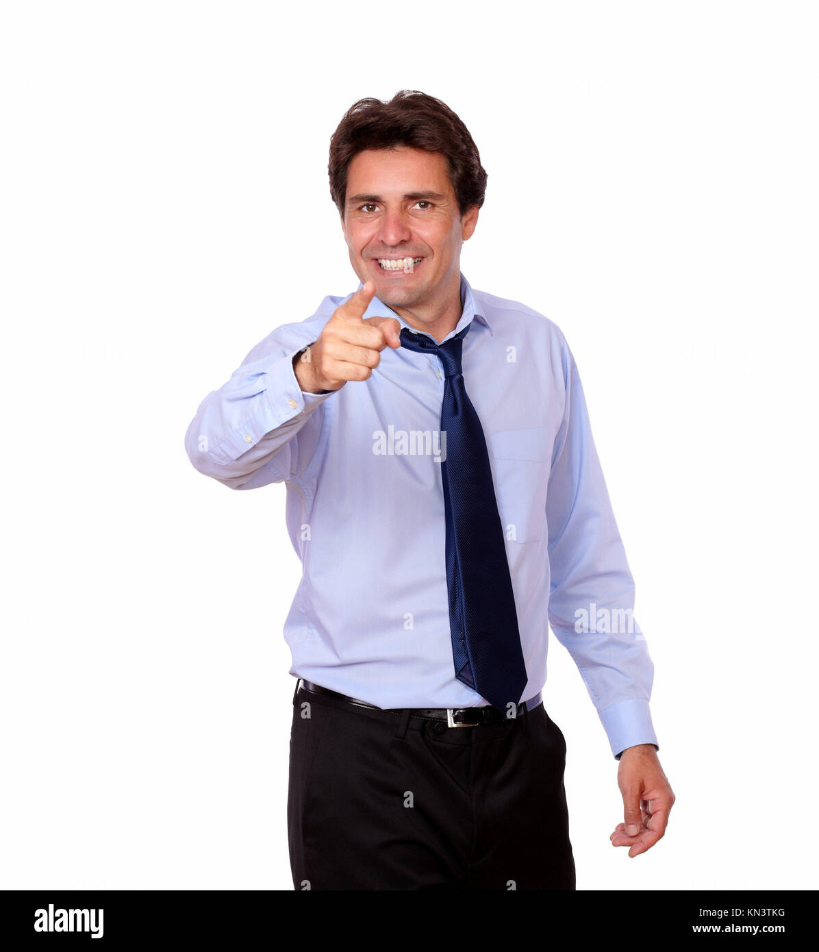 Retrato de un hombre adulto latino con corbata apuntando a usted mientras está de pie sobre un fondo blanco. Foto de stock