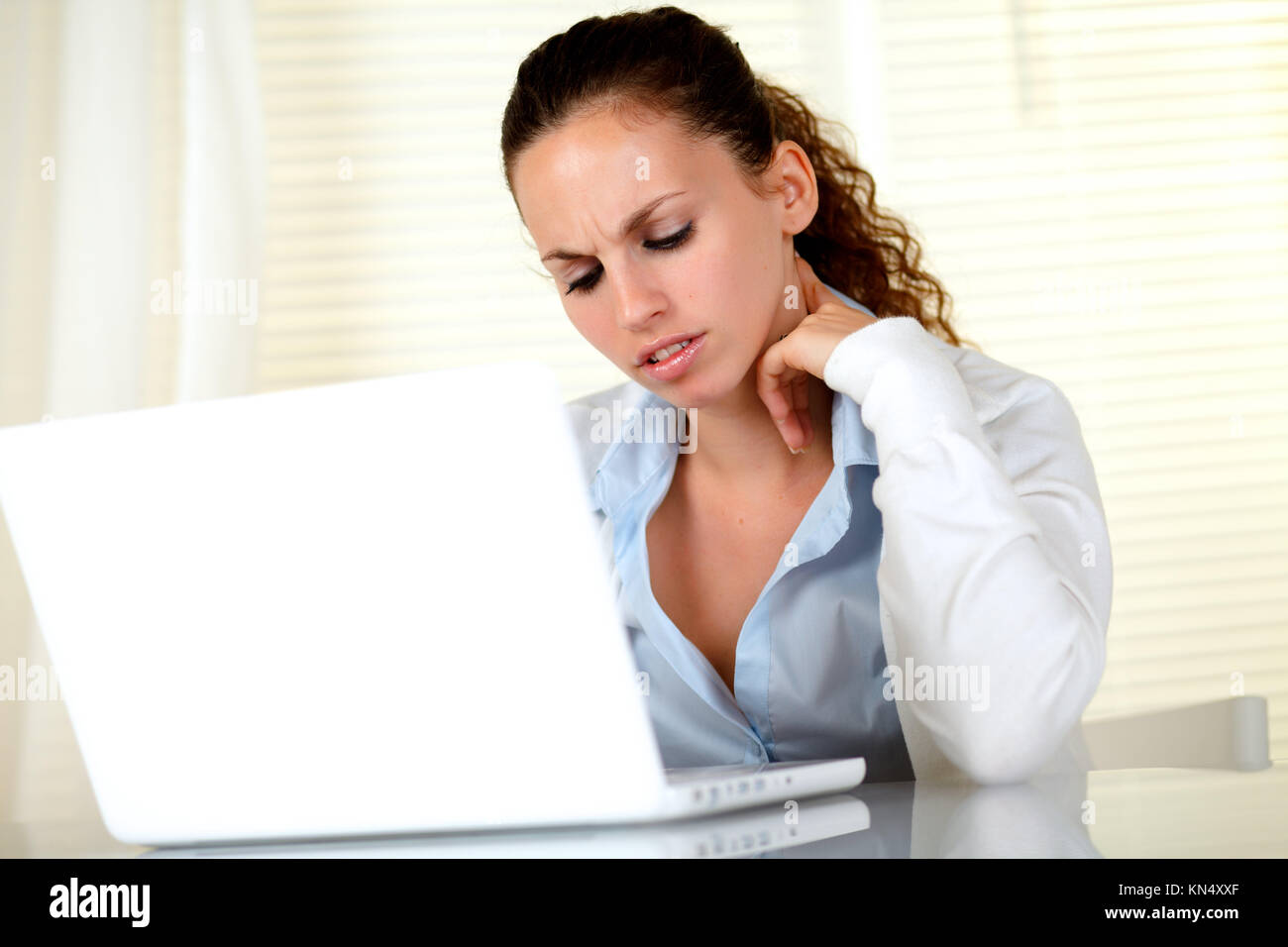 Mujer joven interesado la lectura de la pantalla del portátil en la oficina. Foto de stock