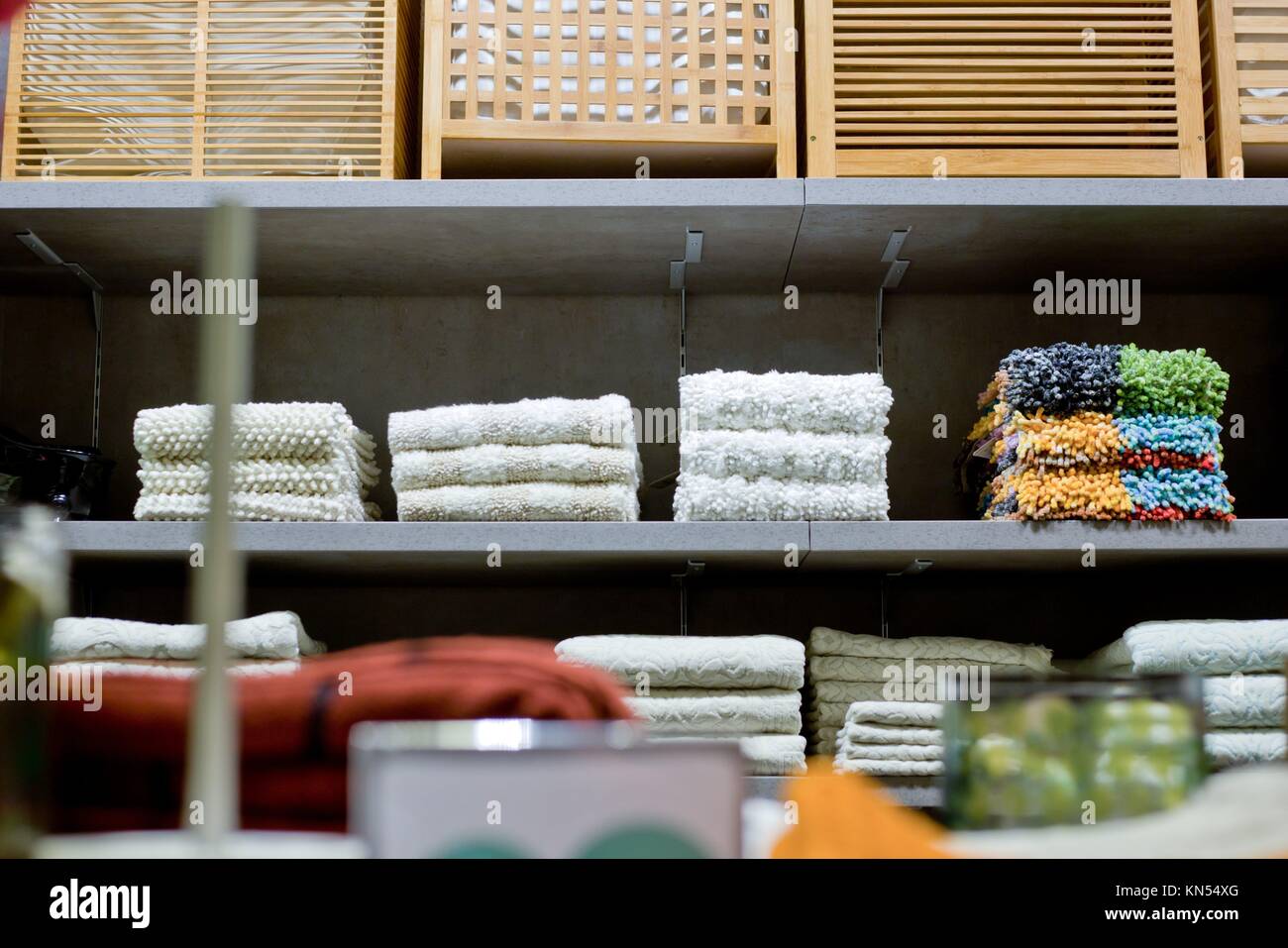 Sucio chothes cestas, alfombras de baño, toallas y otras desgaste en los estantes. Foto de stock