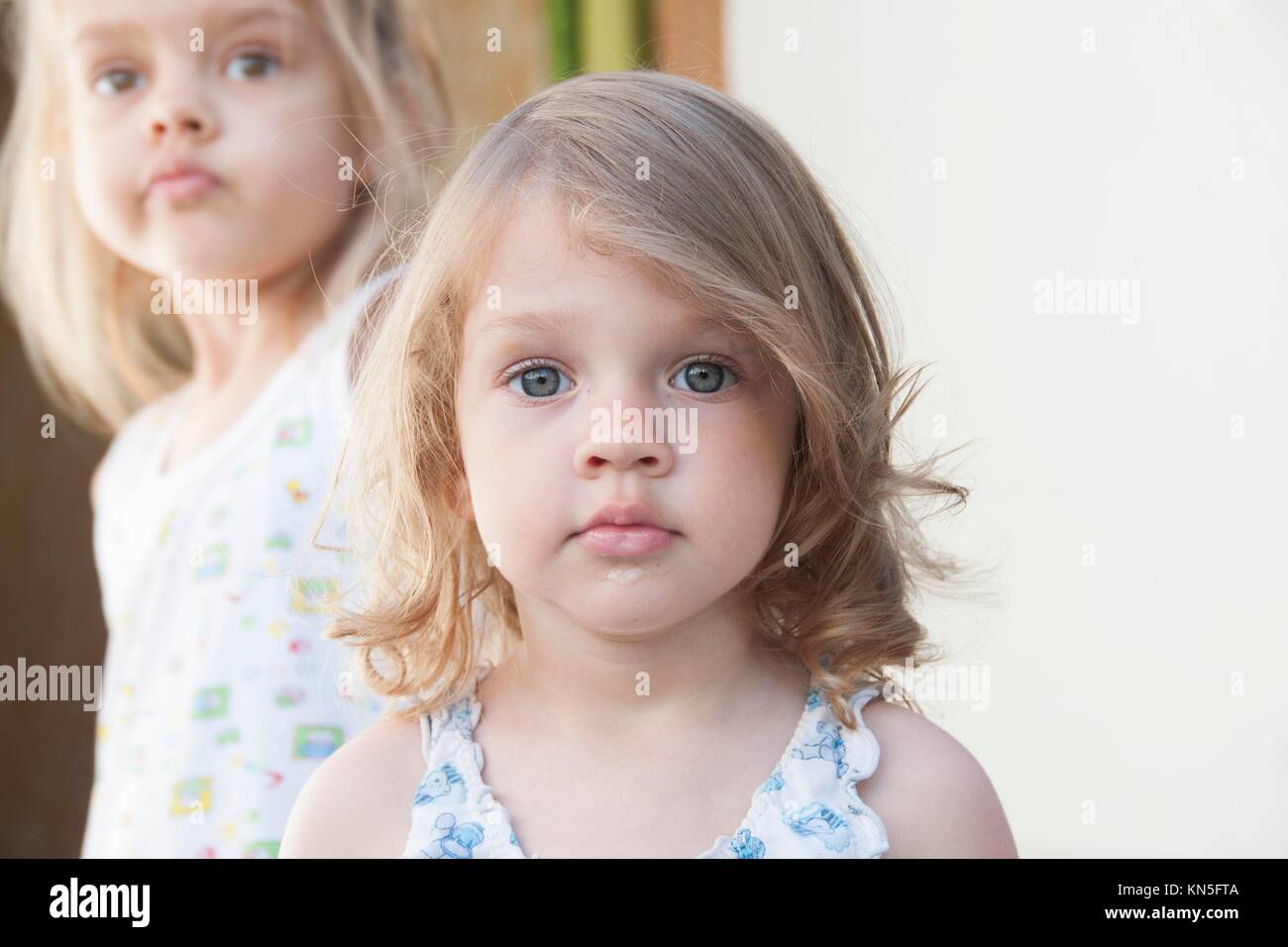 retrato de dos niñas: niña de cuatro años en el fondo, dos
