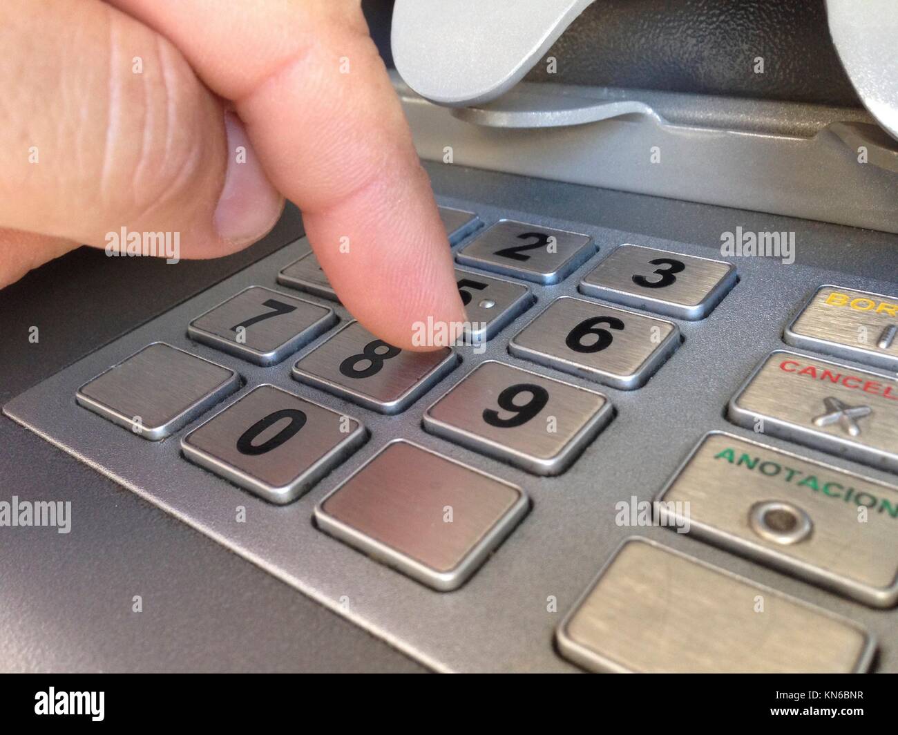 El hombre dedo pulsando el número de la contraseña en la máquina ATM. Foto de stock