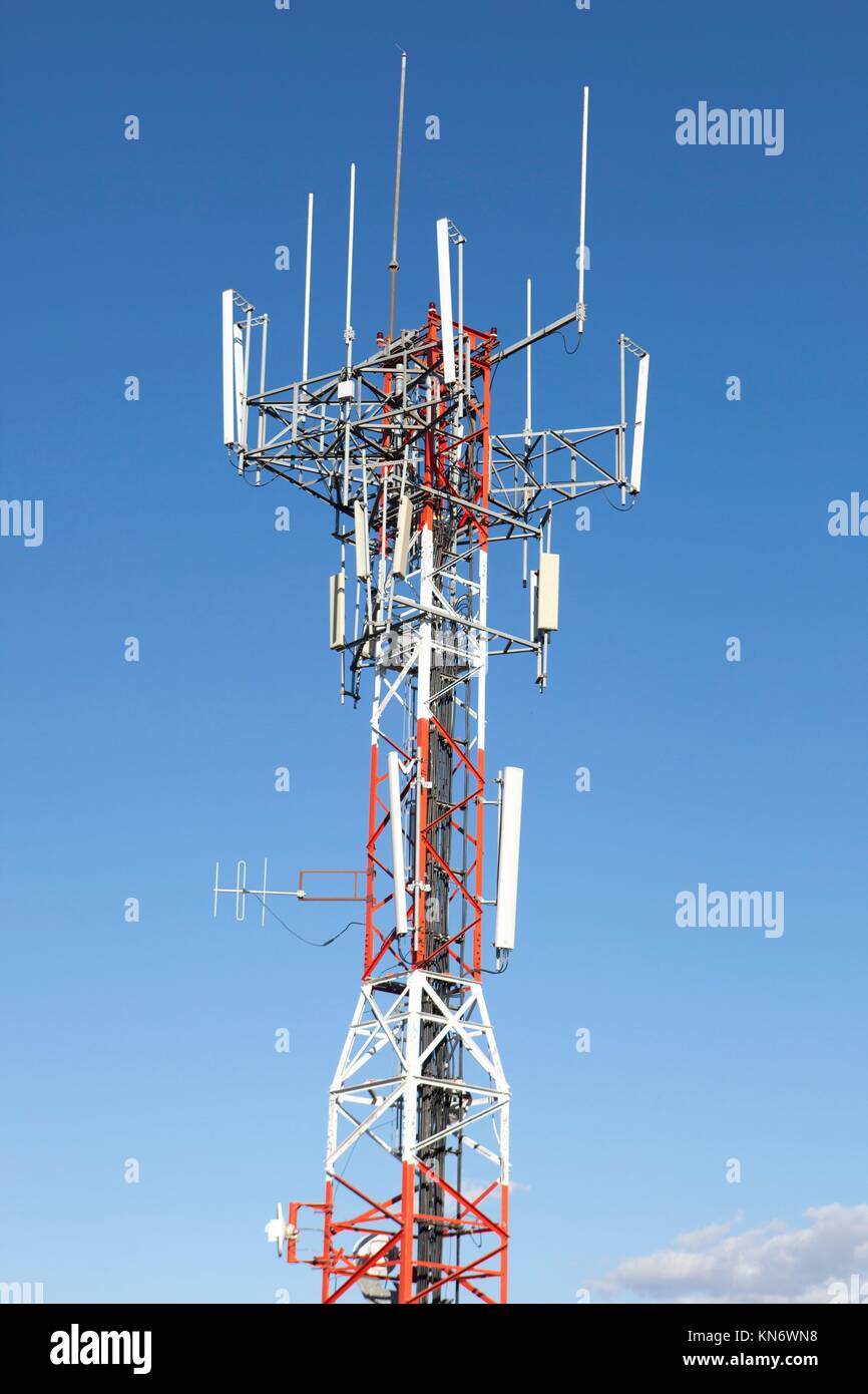 Teléfono móvil de telecomunicaciones a través de la torre de la antena de la Radio blue sky. Foto de stock