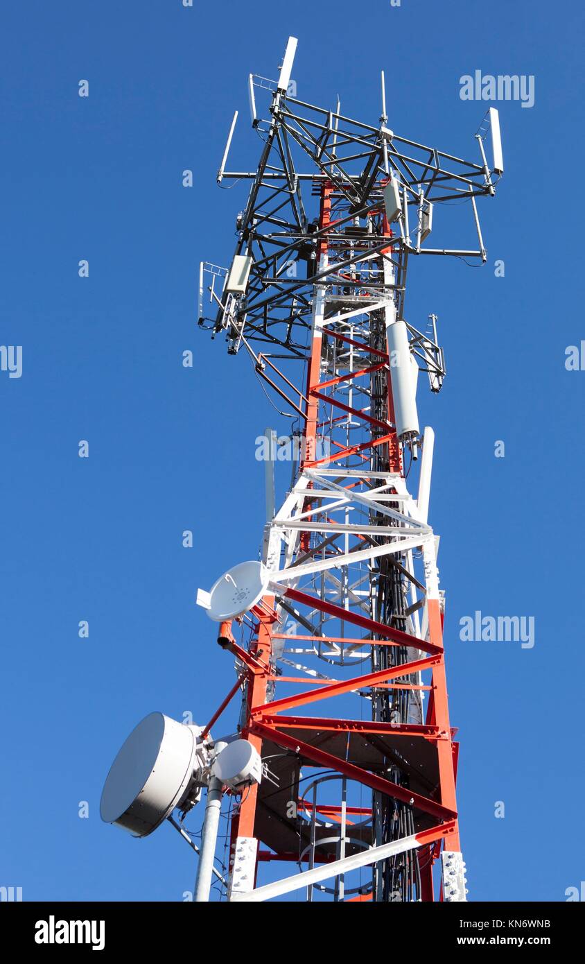 Teléfono móvil de telecomunicaciones a través de la torre de la antena de la Radio blue sky. Foto de stock