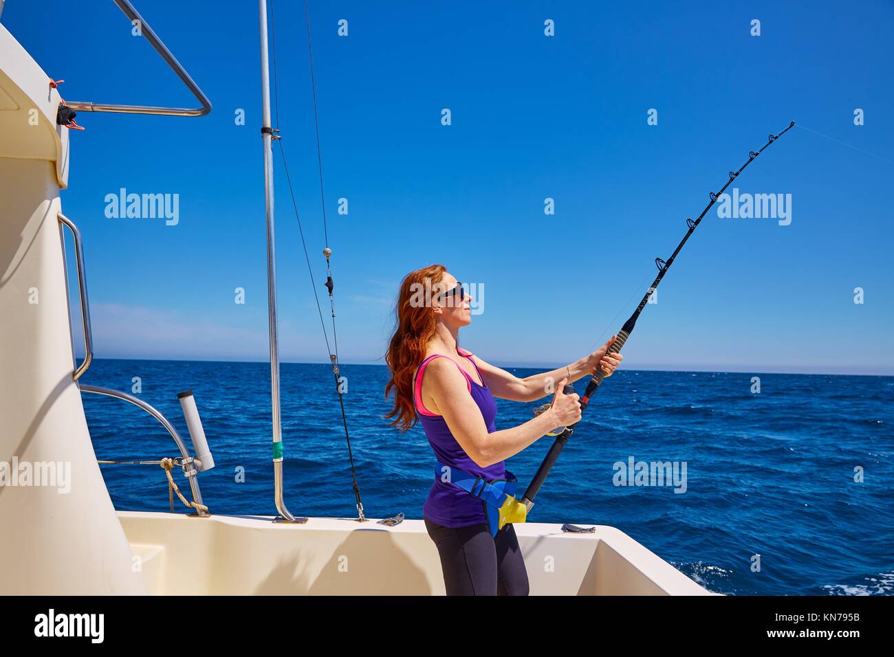 Mujer hermosa chica caña de pesca curricán en agua salada en un barco  curricán Fotografía de stock - Alamy