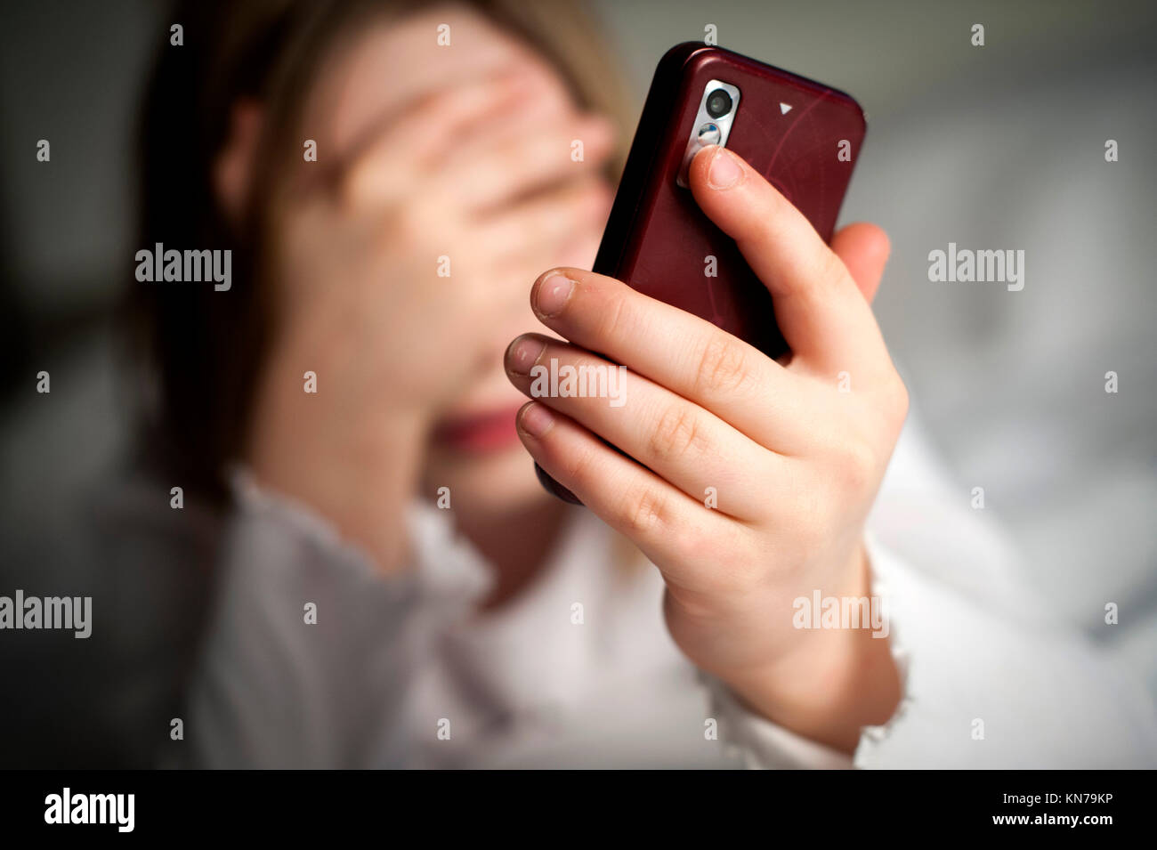 Malas noticias para una niña con un teléfono inteligente en los medios de comunicación social. Foto de stock