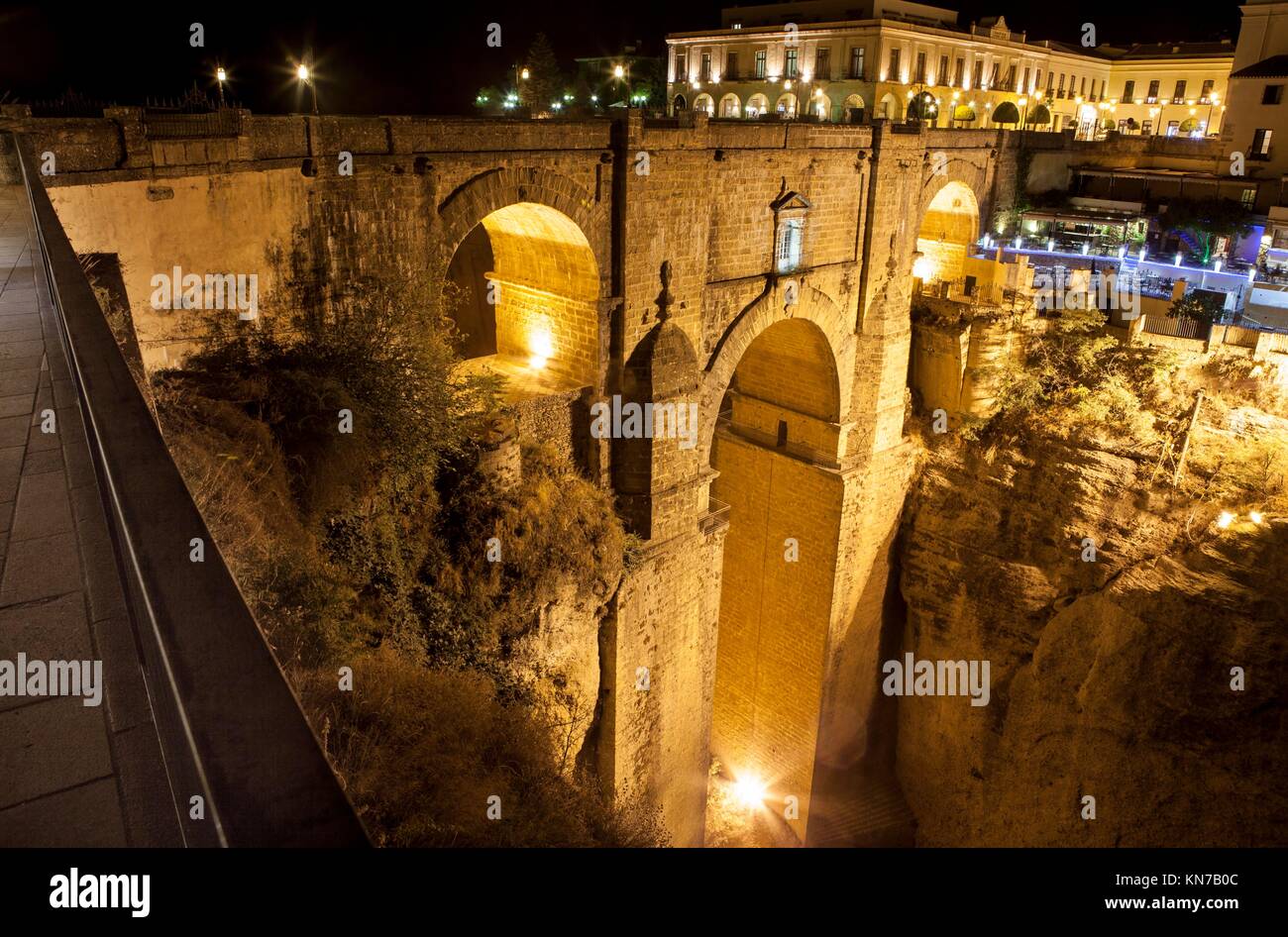 Iluminado puente del casco antiguo de la ciudad de Ronda, España. Una escena nocturna. Foto de stock