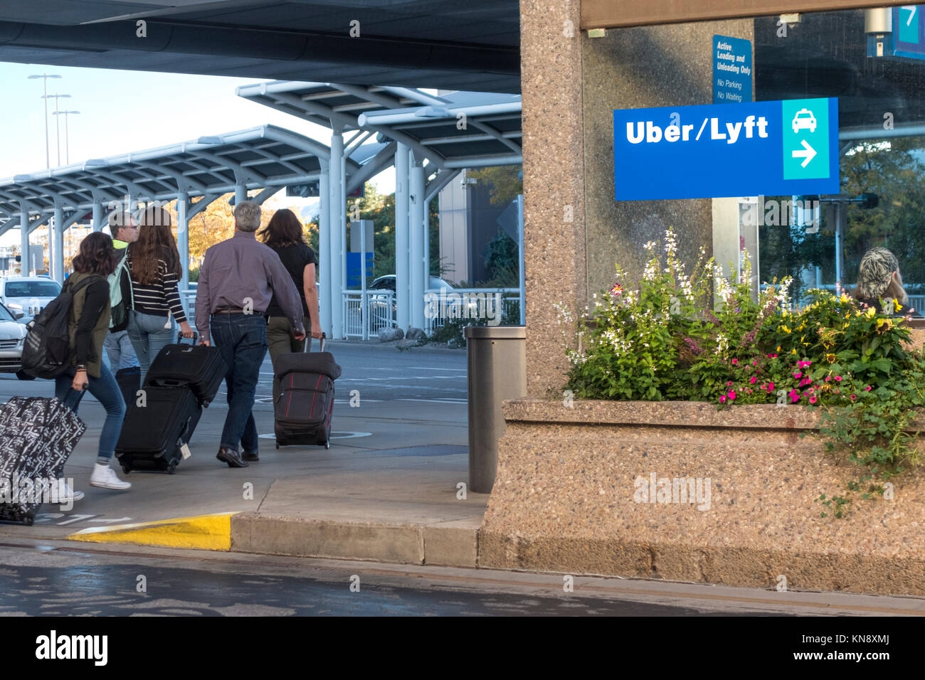 Signo Lyft Uber taxis en el Aeropuerto Internacional de Salt Lake City. Los pasajeros con equipaje. Foto de stock