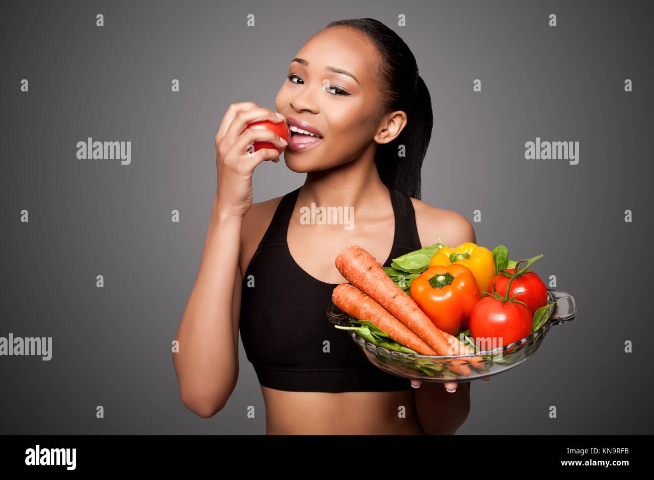 Hermosa mujer asiática negro feliz saludable comer deliciosas verduras. Foto de stock