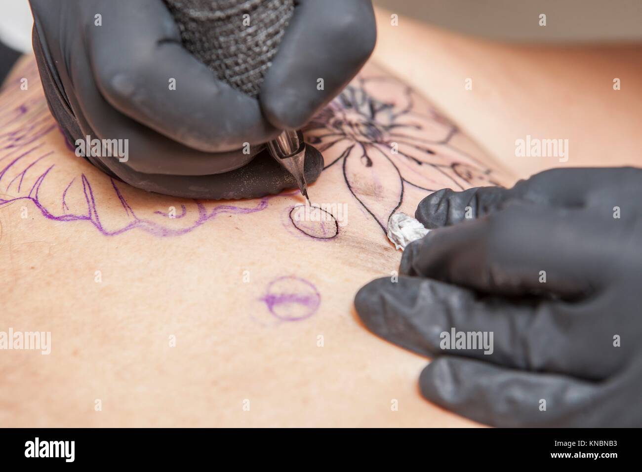 Tatuajes Tatuajes se aplica para el omóplato de una mujer. Primer plano de  la tinta del lápiz máquina inyectando tinta negra Fotografía de stock -  Alamy