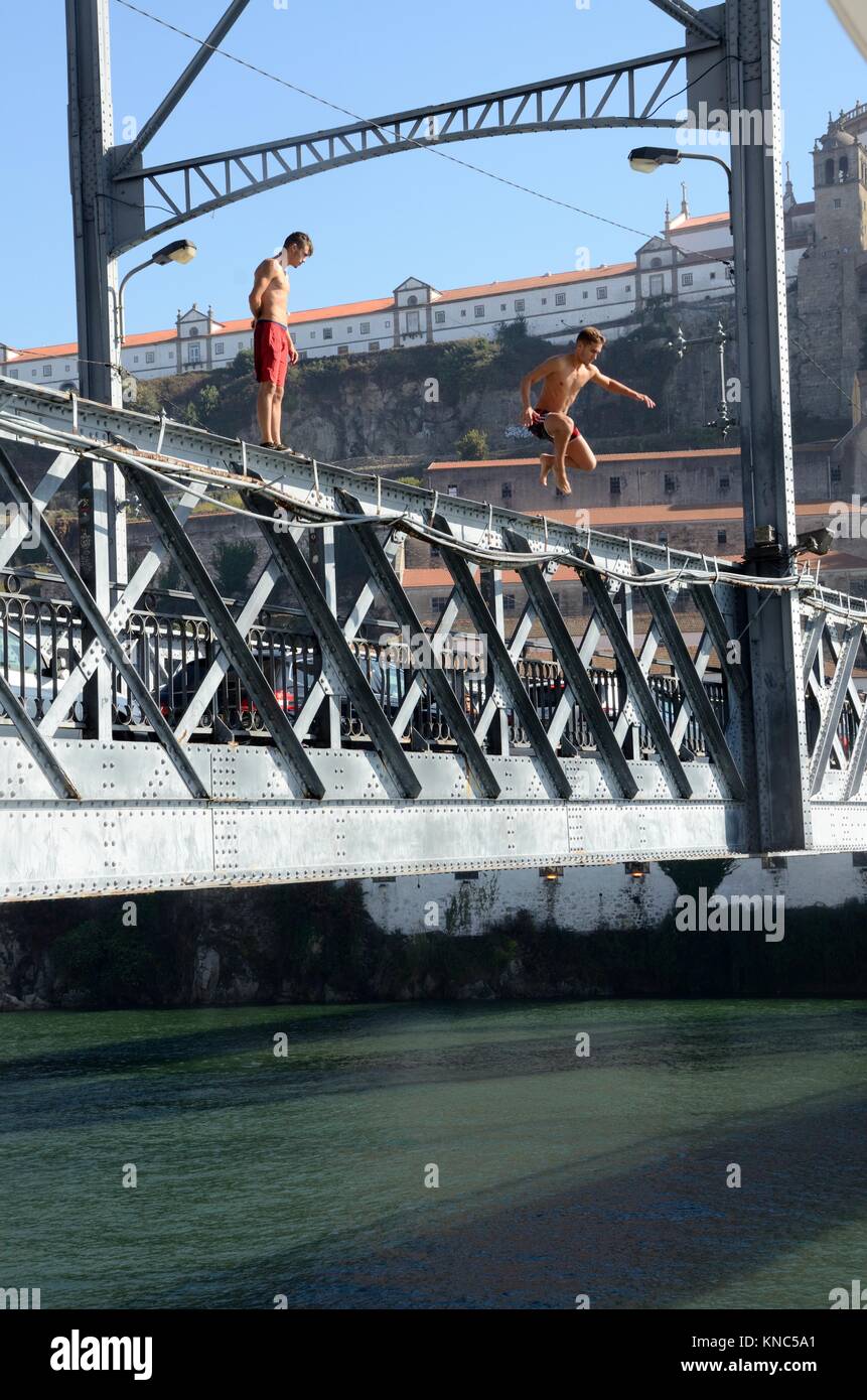 Jóvenes saltando de Luis ! Puente para entretener a los turistas para dinero Porto Portugal Foto de stock