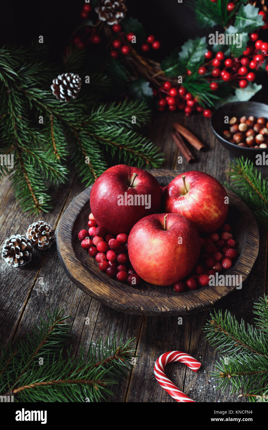 Manzanas rojas, arándanos y ramas de abeto. Navidad todavía la vida. Papel tapiz de invierno. Composición vertical Foto de stock