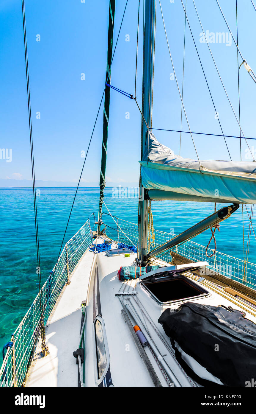 Vista frontal del barco de vela en el mar. Arco lateral del yate o velero deslizándose por mar en calma en el mar Adriático en el día soleado. Foto de stock