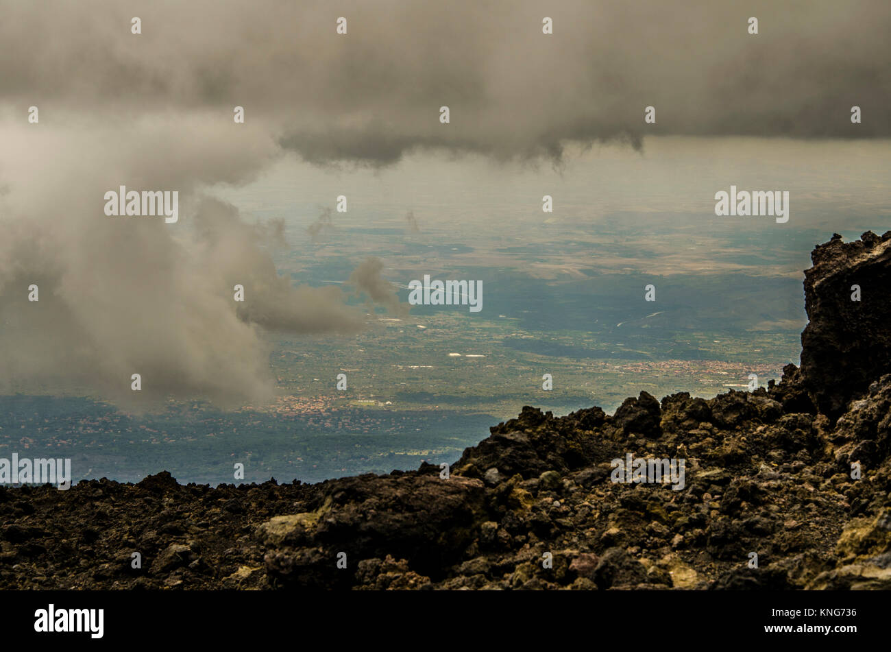 Vista del territorio de Sicilia entre nubes desde la cima del volcán Etna. Foto de stock