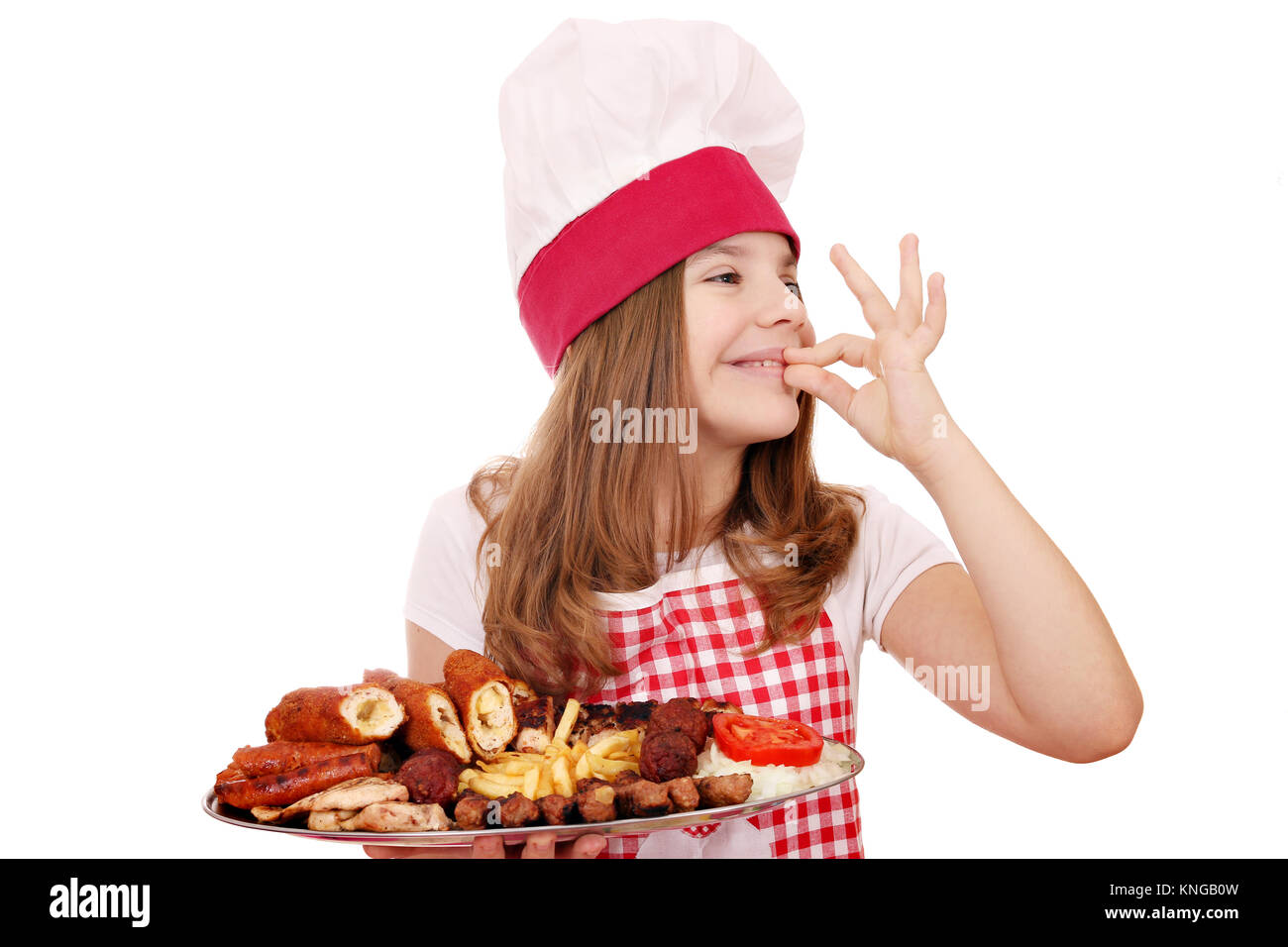 Little Girl cocinar con carne asada en la placa y signo de mano ok Foto de stock