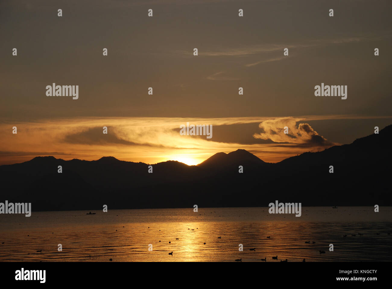 Amanecer en el Lago Atitlán en Guatemala, el cual está rodeado por altos acantilados y daba por tres volcanes Foto de stock