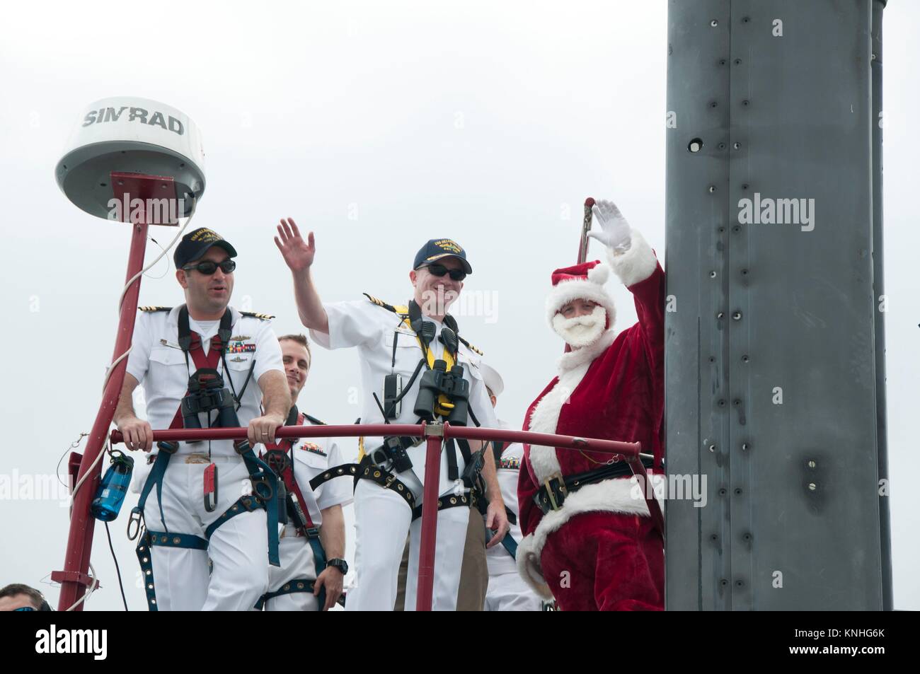 Los marineros estadounidenses y un Santa Claus imitador, saludar a sus amigos y familiares durante un regreso celebración para el USN de ataque de clase Los Angeles submarino USS Oklahoma City, 8 de diciembre de 2016 en el puerto de Apra, Guam. (Foto por PO1 Jamica Johnson via Planetpix) Foto de stock