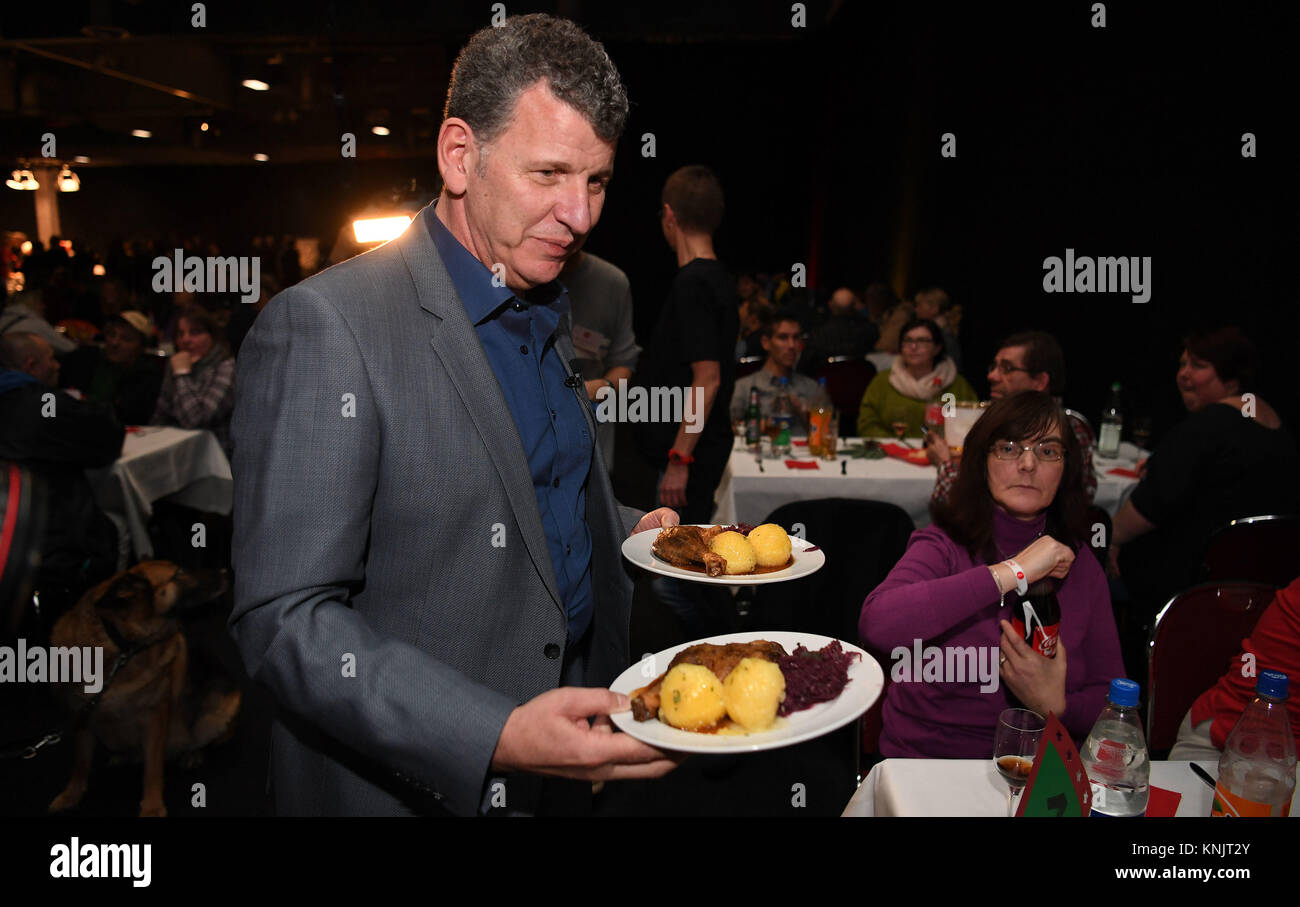 Bremen, Alemania. 12 dic, 2017. La estrella de la música alemana Semino Rossi ayuda a servir las piernas de pato con repollo rojo dumplings y en la sala de exposiciones 4 durante una comida de caridad en Bremen, Alemania, 12 de diciembre de 2017. Alrededor de 800 hombres y mujeres, entre ellas varias personas sin hogar, fueron invitados al evento 'tu fiesta - una noche para la gente en necesidad". Crédito: Carmen Jaspersen/dpa/Alamy Live News Foto de stock