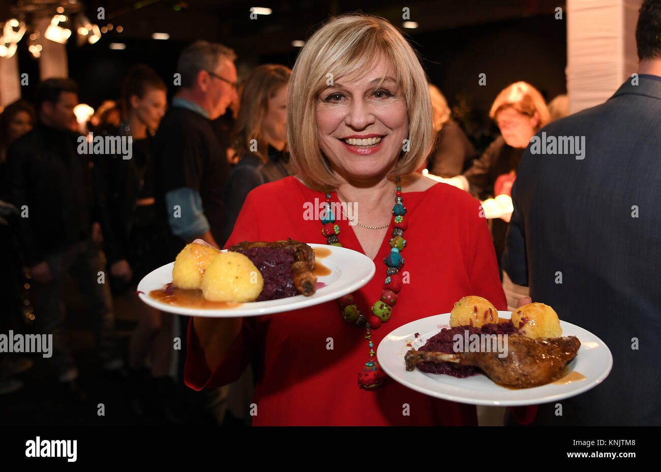 Bremen, Alemania. 12 dic, 2017. La estrella de la música alemana María Roos ayuda a servir las piernas de pato con repollo rojo dumplings y en la sala de exposiciones 4 durante una comida de caridad en Bremen, Alemania, 12 de diciembre de 2017. Alrededor de 800 hombres y mujeres, entre ellas varias personas sin hogar, fueron invitados al evento 'tu fiesta - una noche para la gente en necesidad". Crédito: Carmen Jaspersen/dpa/Alamy Live News Foto de stock