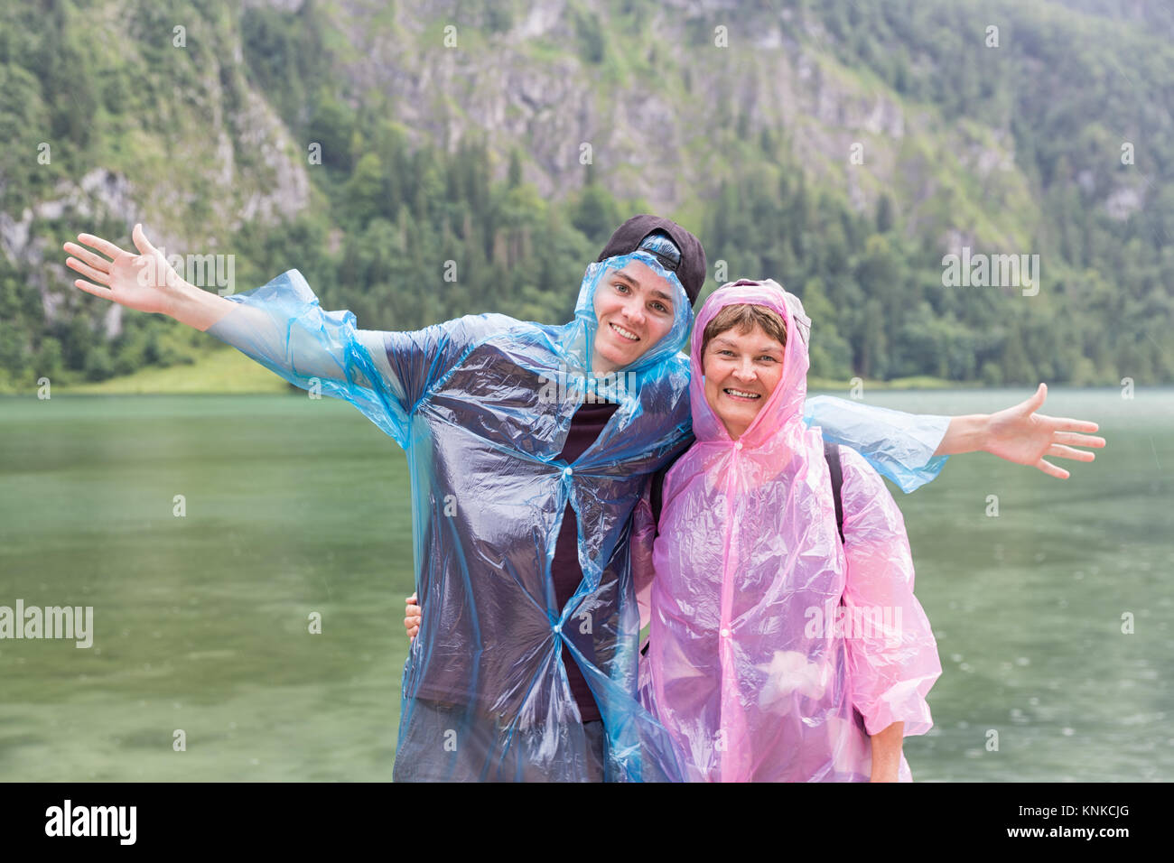 Madre e hijo con impermeables en la costa alemana de Konigssee Foto de stock