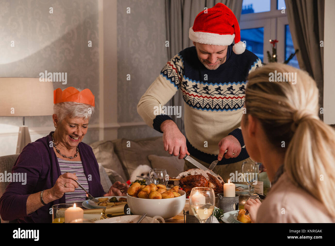 Punto de vista foto de familia la cena de Navidad. El hombre es cortar el pavo. Foto de stock