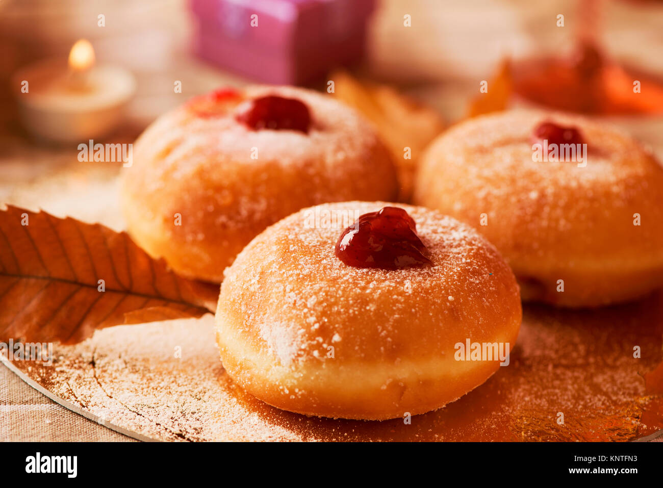 Primer plano de algunas sufganiyot, judía donuts rellenos con jalea de  fresa se consumen tradicionalmente en Janucá, y algunas velas encendidas  sobre una mesa Fotografía de stock - Alamy